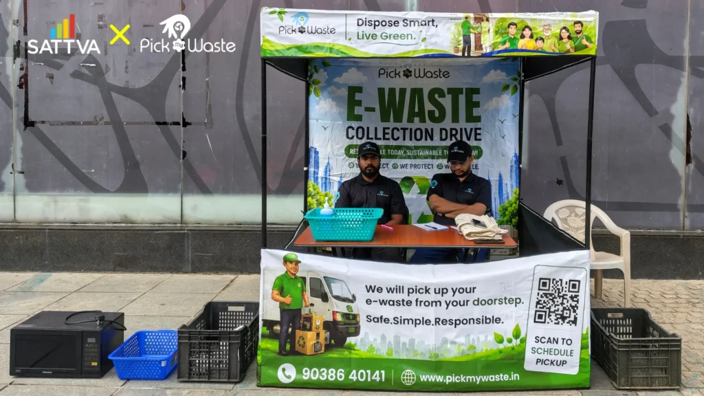 PickMyWaste team members sitting at the official e-waste collection drive registration booth at Sattva Gold Summit, Bengaluru.